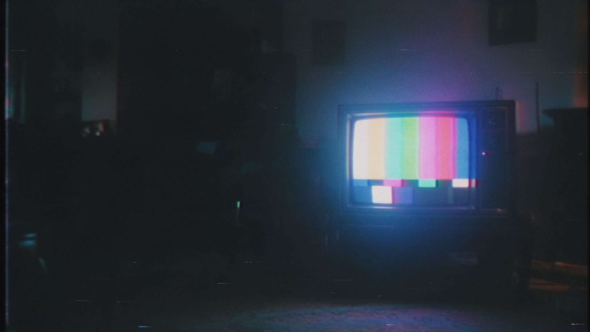 A CRT television glowing in a dark room, shot on VHS