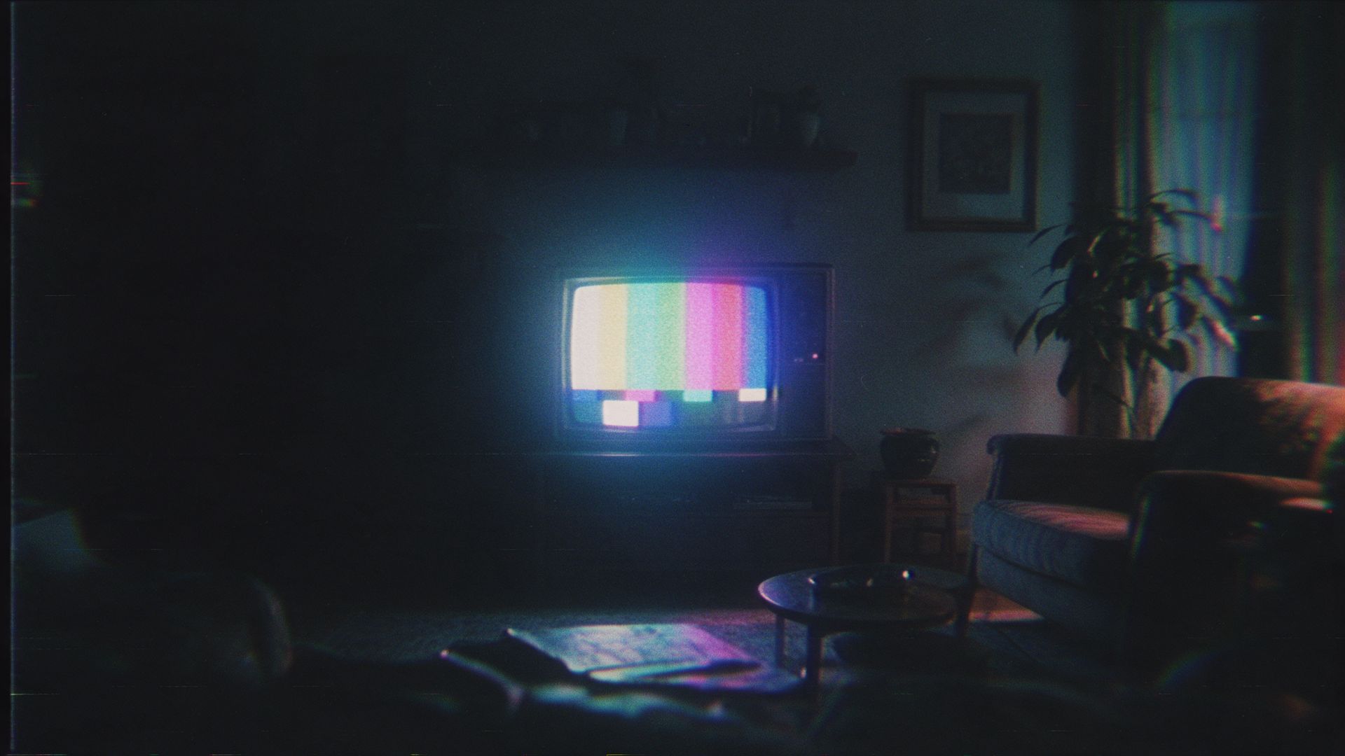 A dim room lit only by a television
